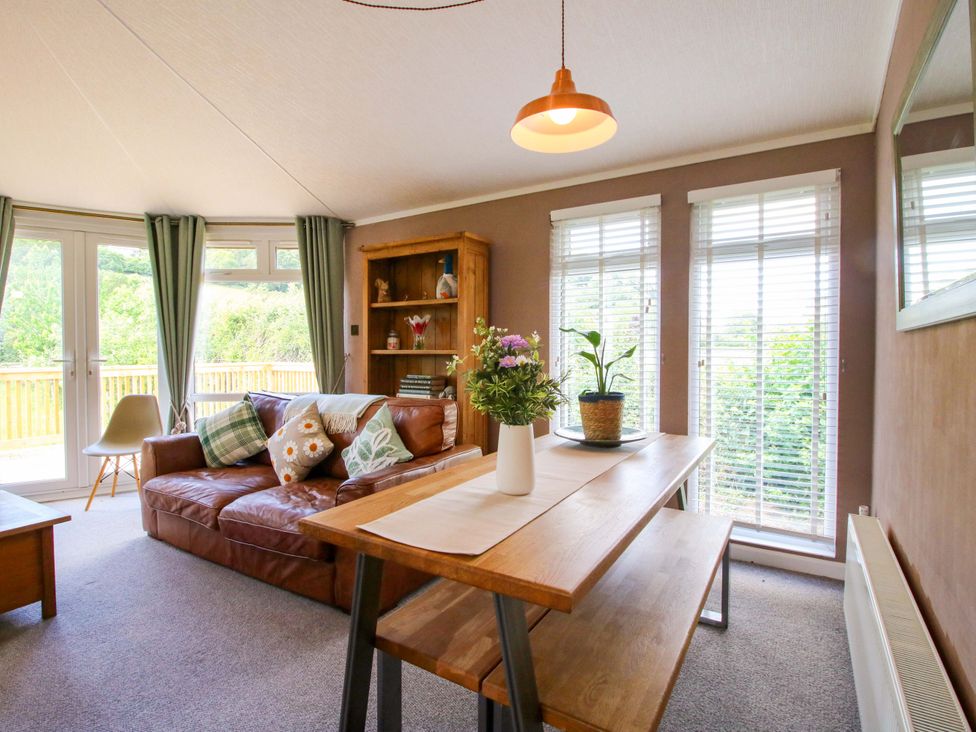 A living room with a sofa, table, and chairs at Dunromin in Montgomery