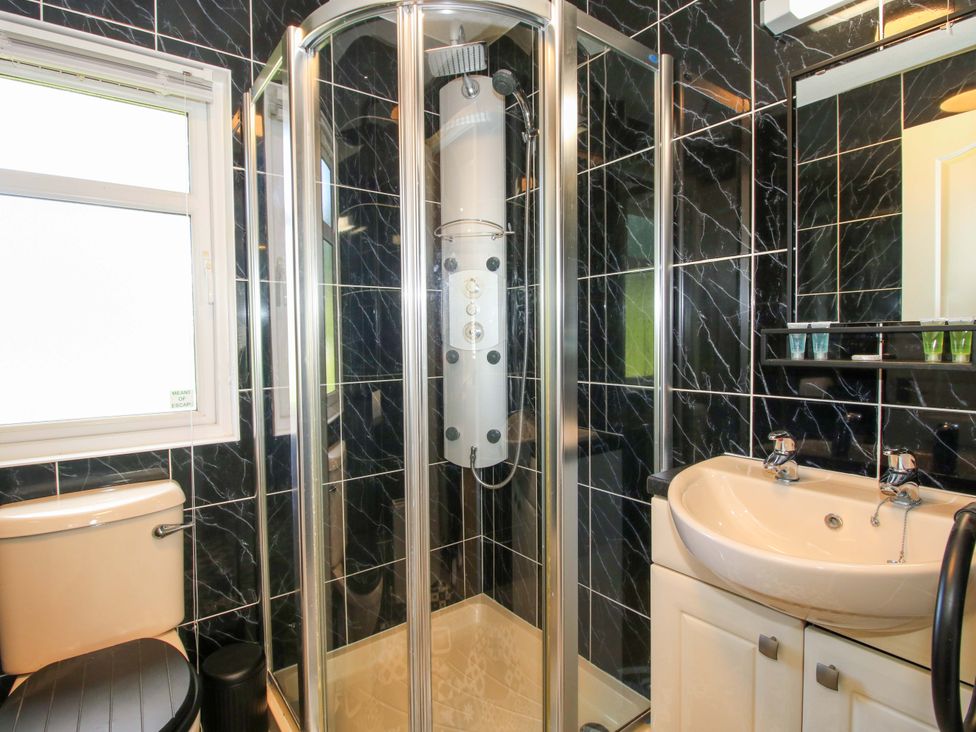 A bathroom with a shower, toilet, and sink at Dunromin Montgomery