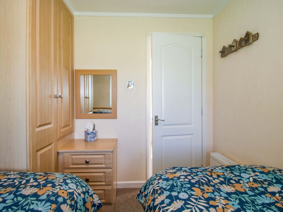 A bedroom with two beds and a mirror at Dunromin in Montgomery