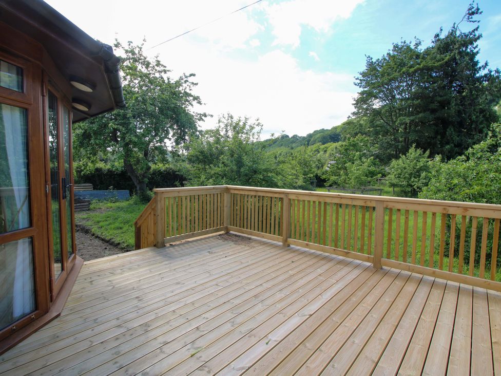 A deck area with railings and trees in the background at Dunromin in Montgomery