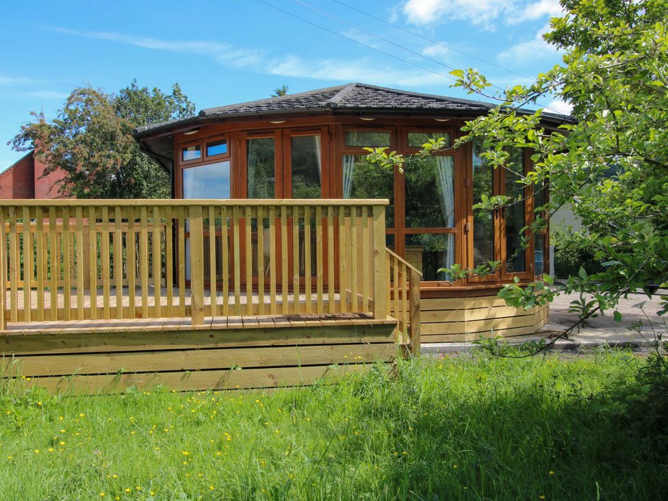 A garden structure with wooden deck and railing at Dunromin Montgomery
