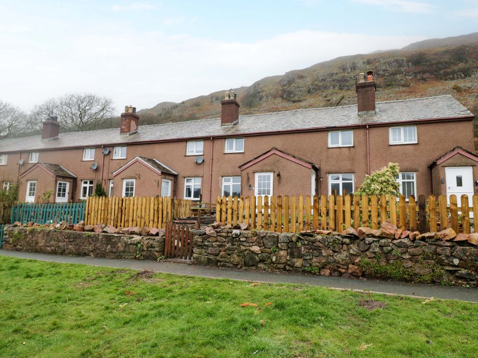 An outdoor view of cottages with a grassy area at Dakota in Boot