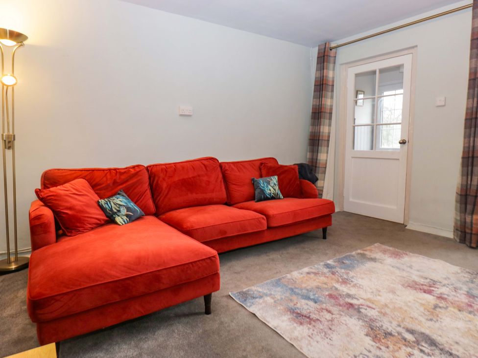 A living room with a red sofa and lamp at Dakota in Boot