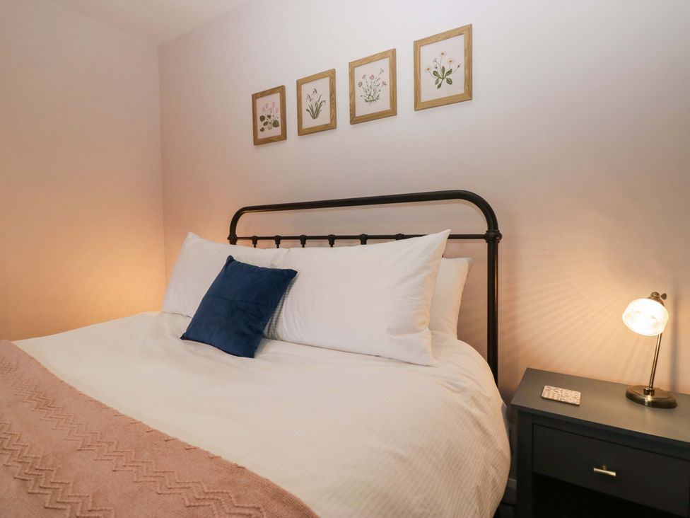 A bedroom with a bed and nightstand at Dakota in Boot