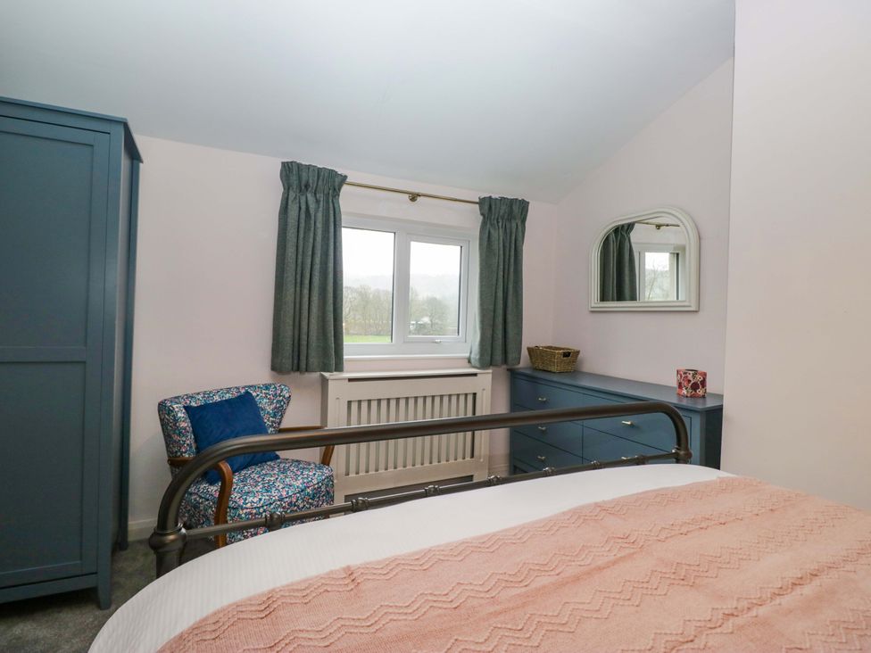 A bedroom with a bed, armchair, and dresser at Dakota in Boot