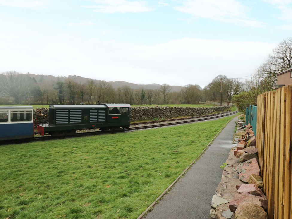 A train on tracks beside grass and path at Dakota in Boot