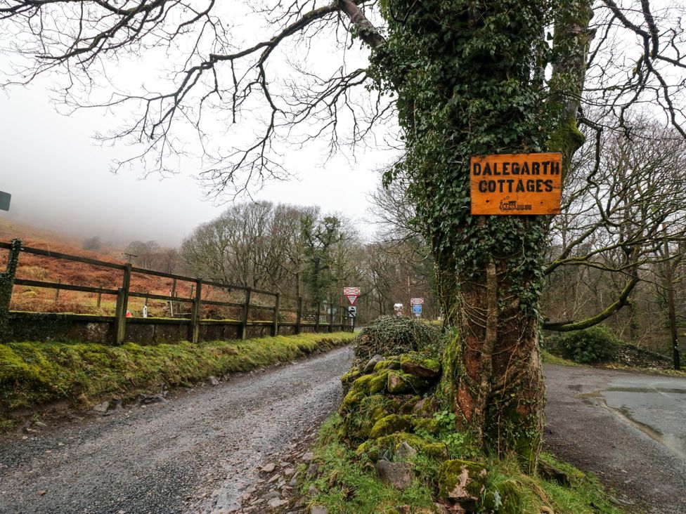 A road with a sign for Dalegarth Cottages and a tree in the foreground at Dakota in Boot