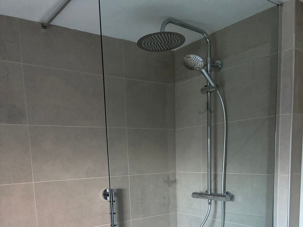 A shower with a modern showerhead at Hen Stabl at Tyn Llan Llanbadrig Cemaes