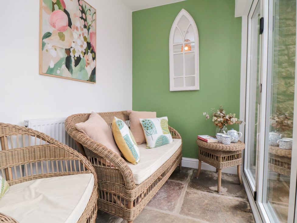 A conservatory with a sofa and coffee table at The Old Chapel in Brompton-By-Sawdon