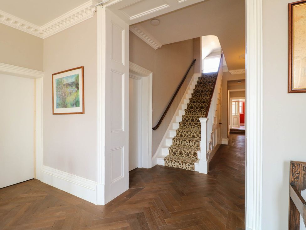 A hallway with a staircase and wall art at Bardon Hill Manor, Coalville