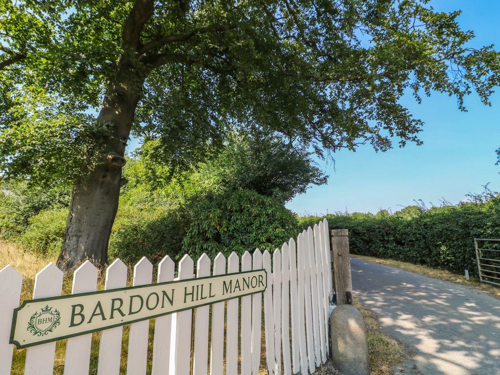 A sign for Bardon Hill Manor next to a tree and road at Bardon Hill Manor in Coalville