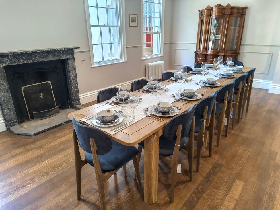 A dining room with a long table set for a meal at Bardon Hill Manor near Coalville