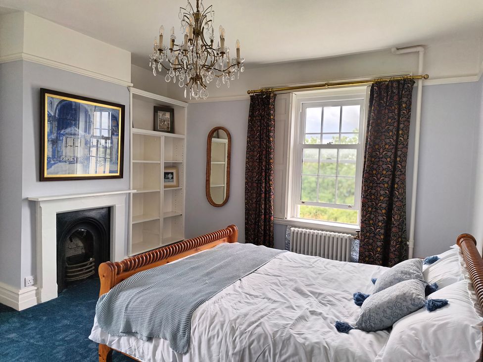 A bedroom with a bed and a chandelier at Bardon Hill Manor near Coalville