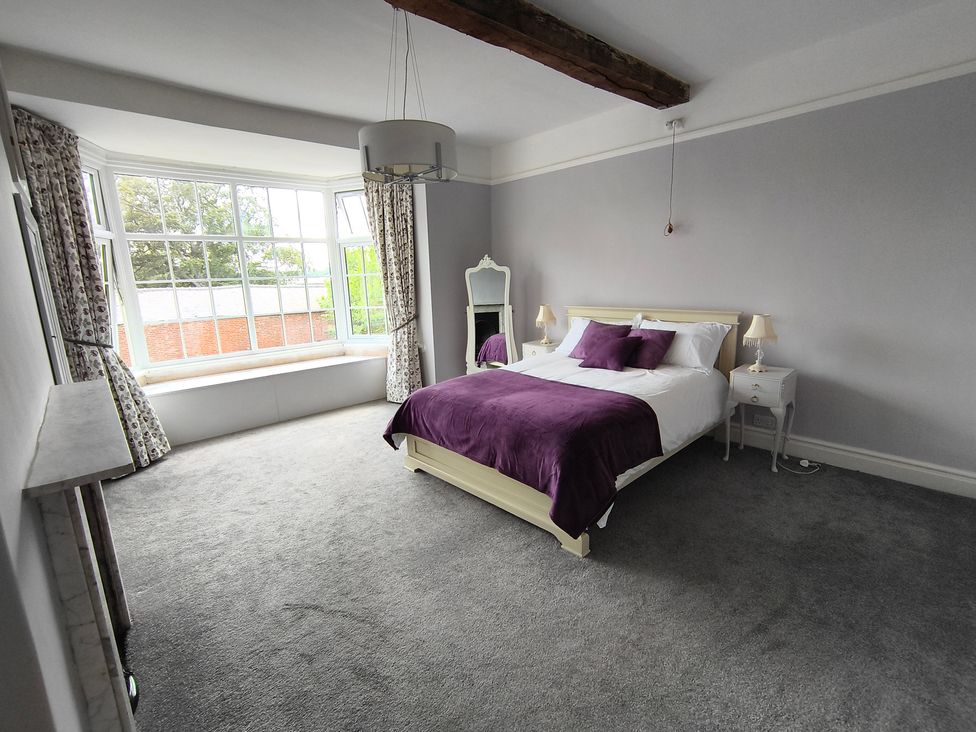 A bedroom with a bed and a mirror at Bardon Hill Manor near Coalville