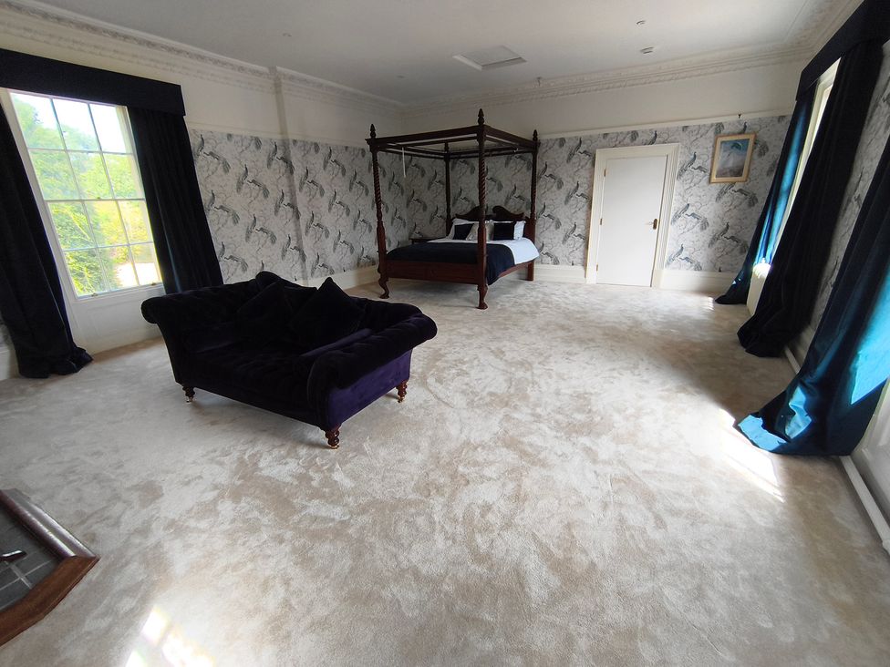 A bedroom with a four-poster bed and a sofa at Bardon Hill Manor Bardon Hill near Coalville