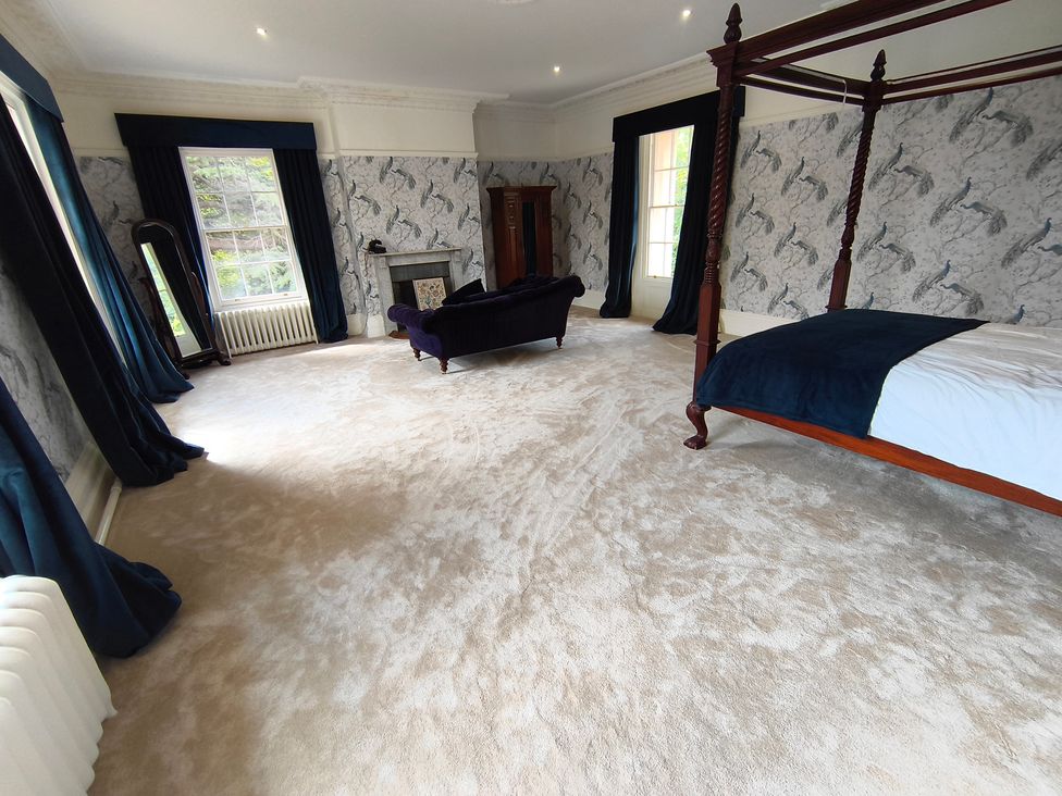 A bedroom with a four-poster bed and a sofa at Bardon Hill Manor near Coalville