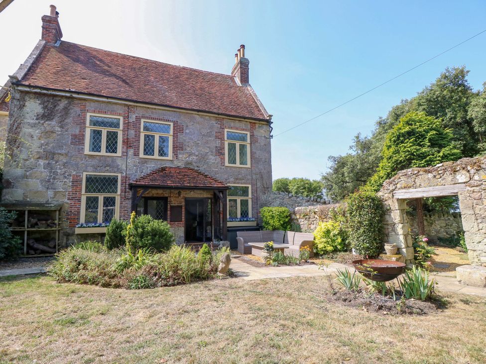An outdoor area with a house, garden, and seating at Glebe Garth in Chale near Niton
