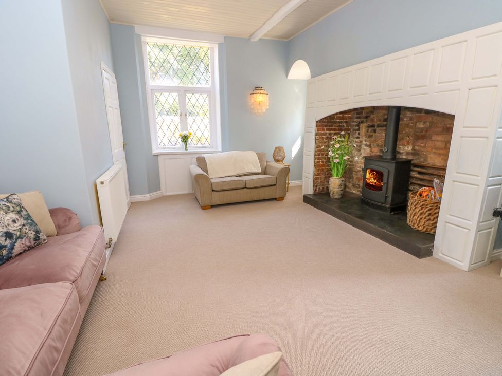 A living room with a fireplace and furniture at Glebe Garth in Chale near Niton