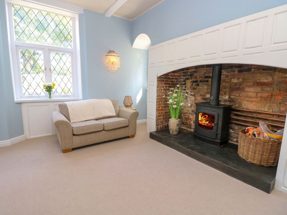 A living room with a sofa and fireplace at Glebe Garth in Chale near Niton