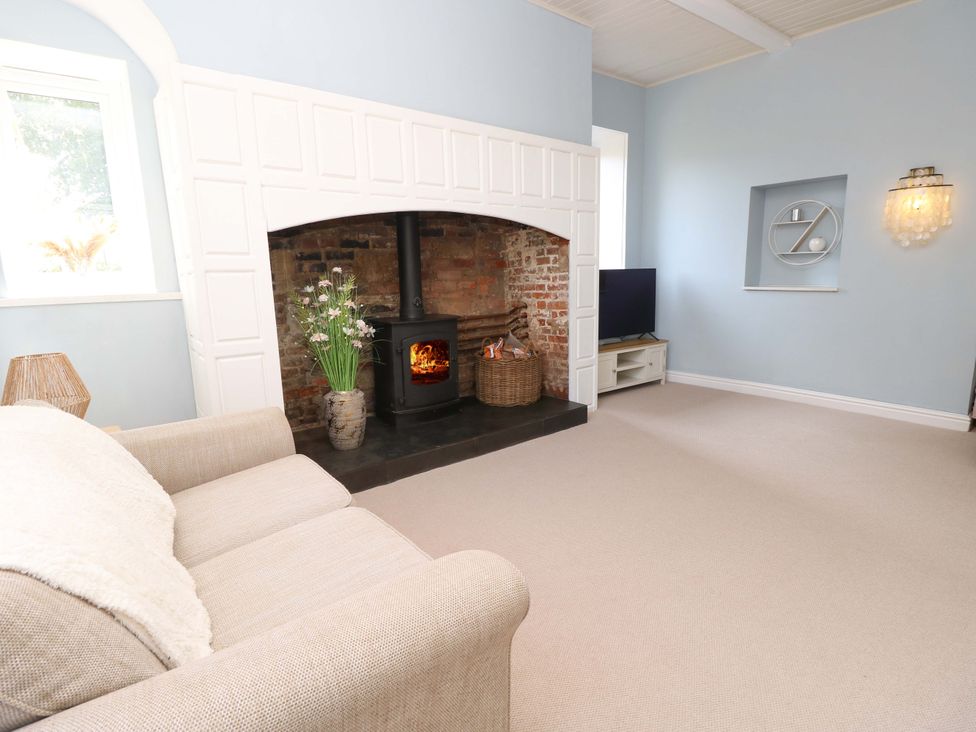 A living room with a fireplace and television at Glebe Garth Chale near Niton