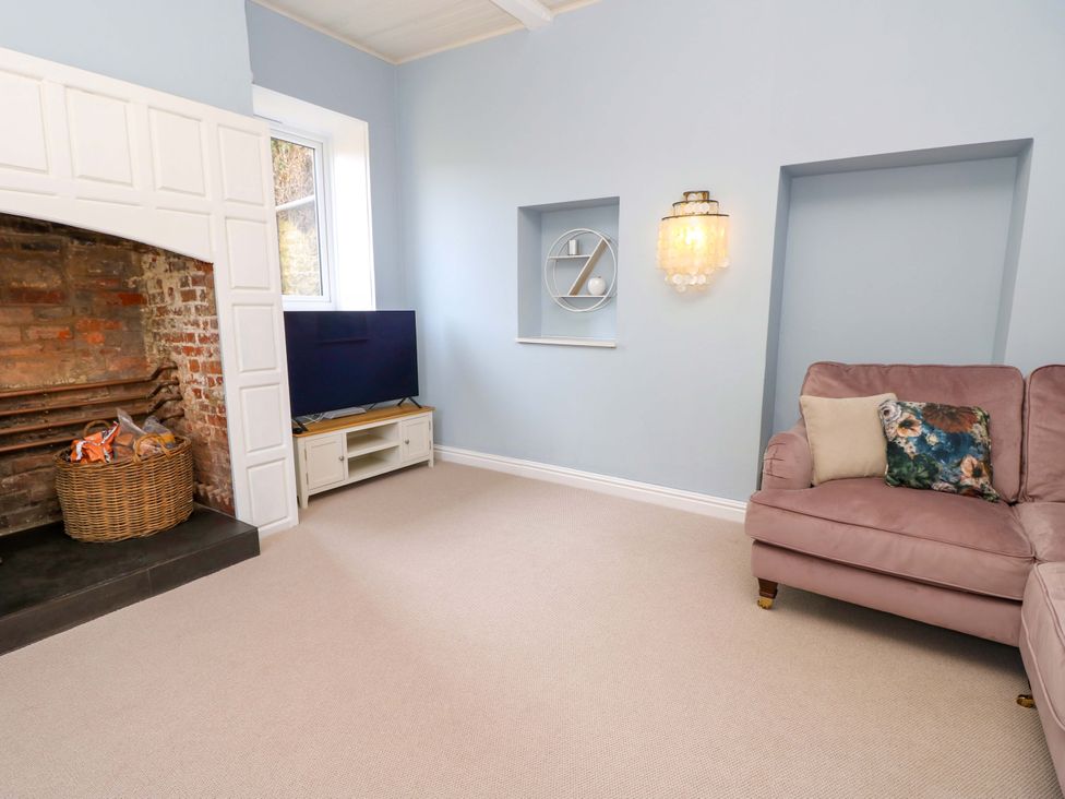A living room with a fireplace and television at Glebe Garth in Chale near Niton