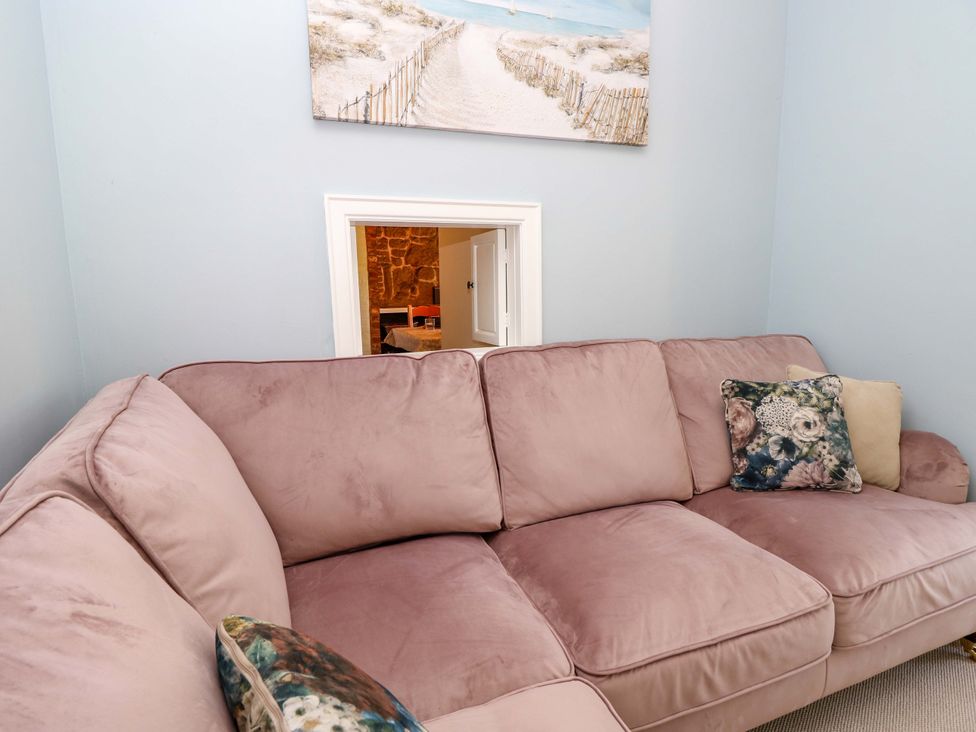 A living room with a sofa and a picture on the wall at Glebe Garth in Chale near Niton