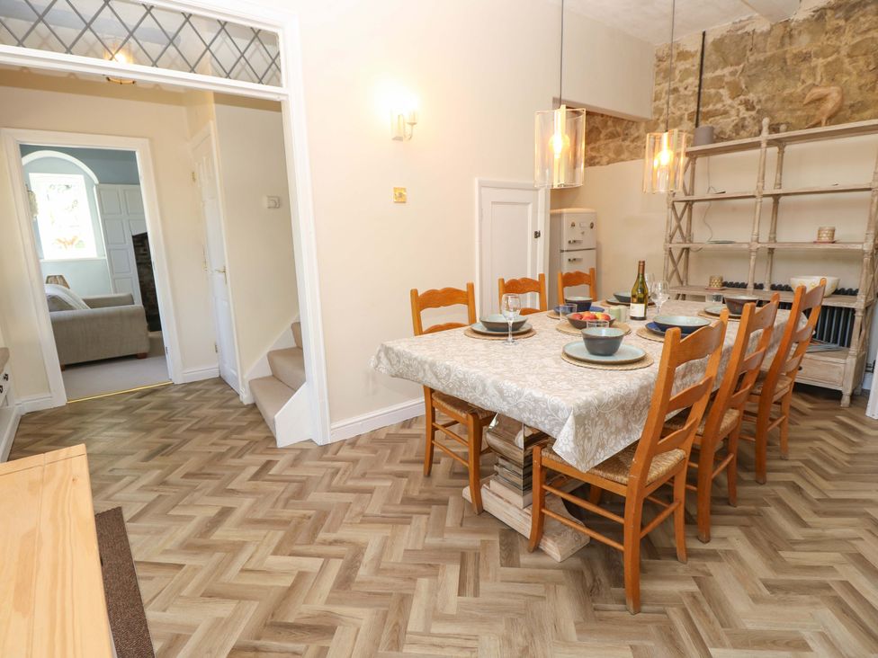 A dining room with a table set for dinner at Glebe Garth in Chale near Niton
