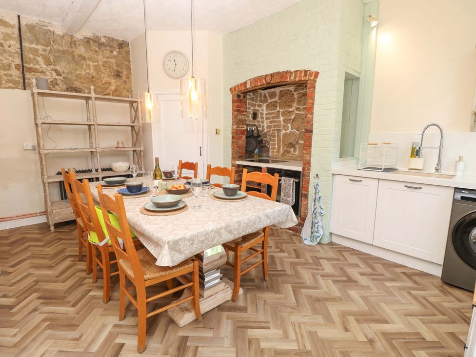 A dining room with a table and chairs at Glebe Garth in Chale near Niton