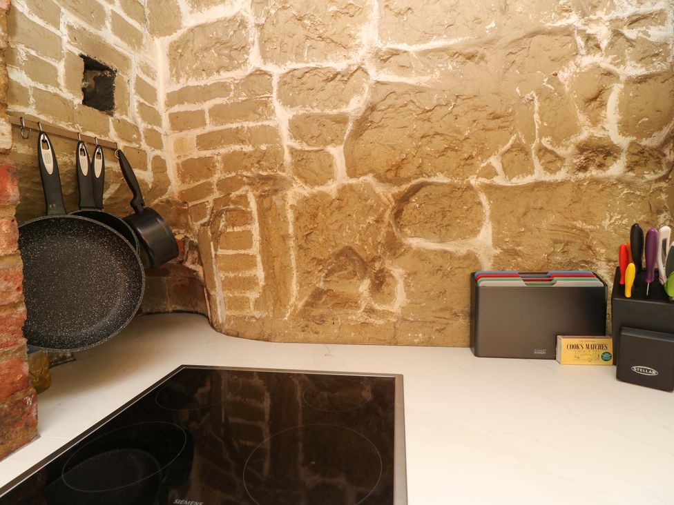 A kitchen area with pots and pans on a wall at Glebe Garth Chale near Niton