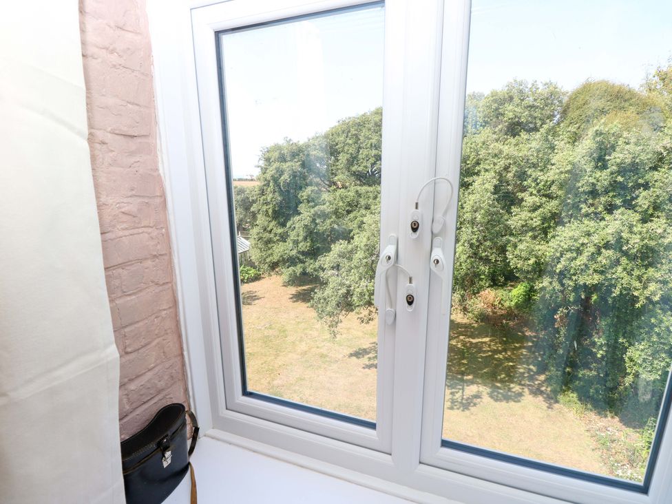 A window with view of trees and grass at Glebe Garth in Chale near Niton