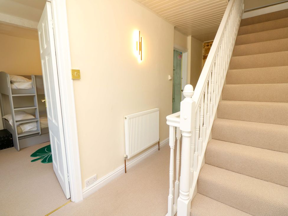 A hallway with a staircase and a bunk bed at Glebe Garth in Chale near Niton