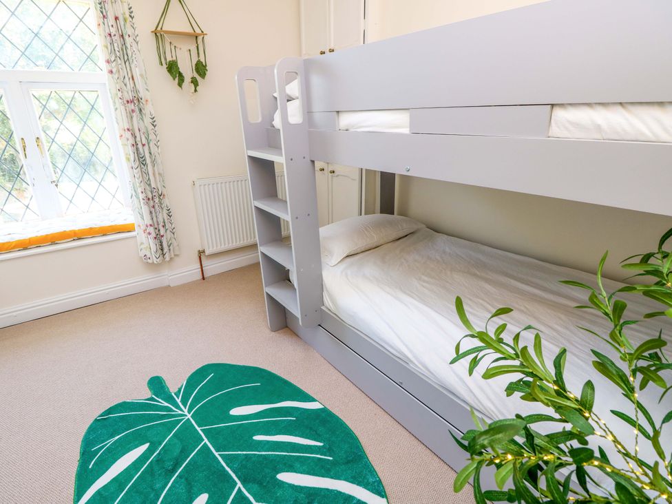 A bedroom with a bunk bed and green rug at Glebe Garth in Chale near Niton