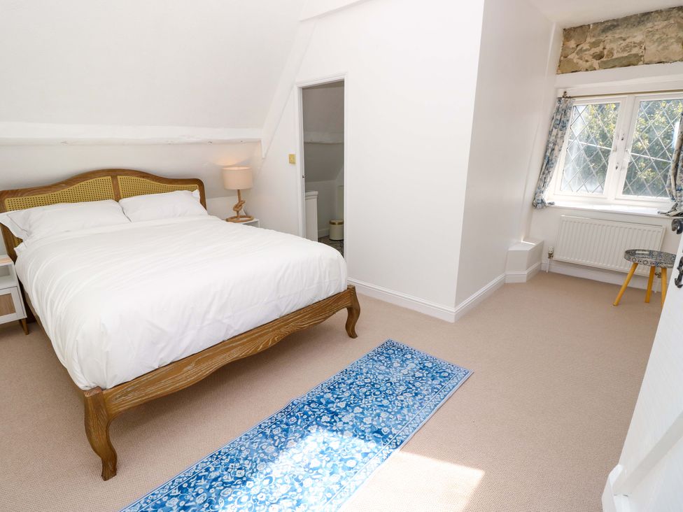 A bedroom with a bed and lamp at Glebe Garth in Chale near Niton