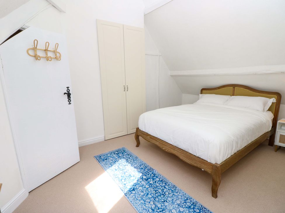 A bedroom with a bed and wardrobe at Glebe Garth in Chale near Niton