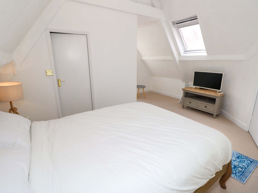 A bedroom with a bed and television at Glebe Garth in Chale near Niton