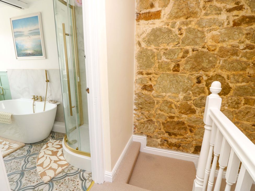 A bathroom with a bathtub and shower at Glebe Garth Chale near Niton