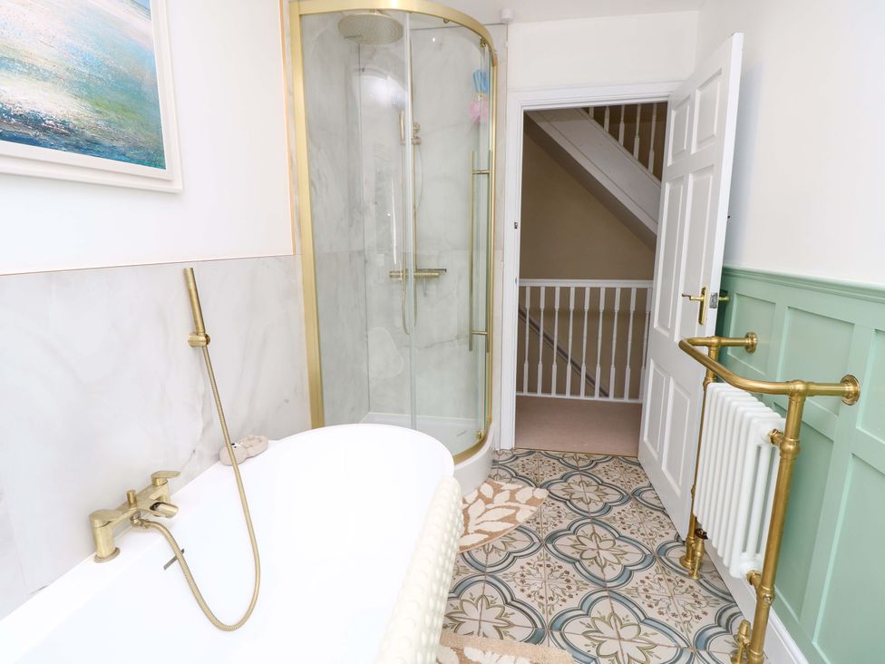 A bathroom with a bathtub and a shower at Glebe Garth in Chale near Niton