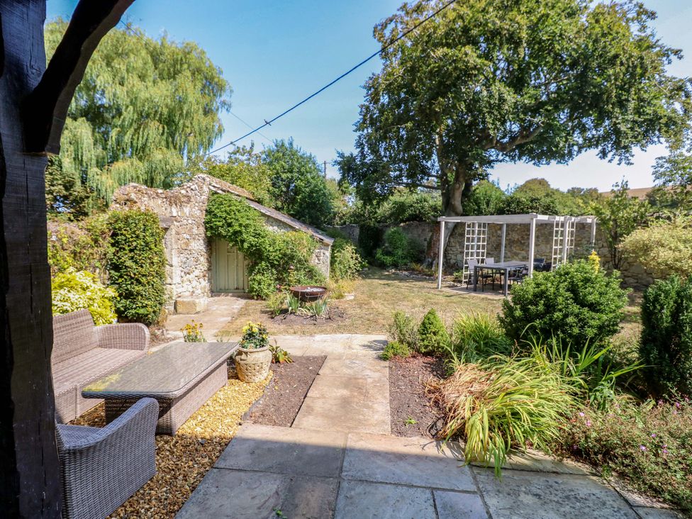A garden with seating and a shed at Glebe Garth in Chale near Niton