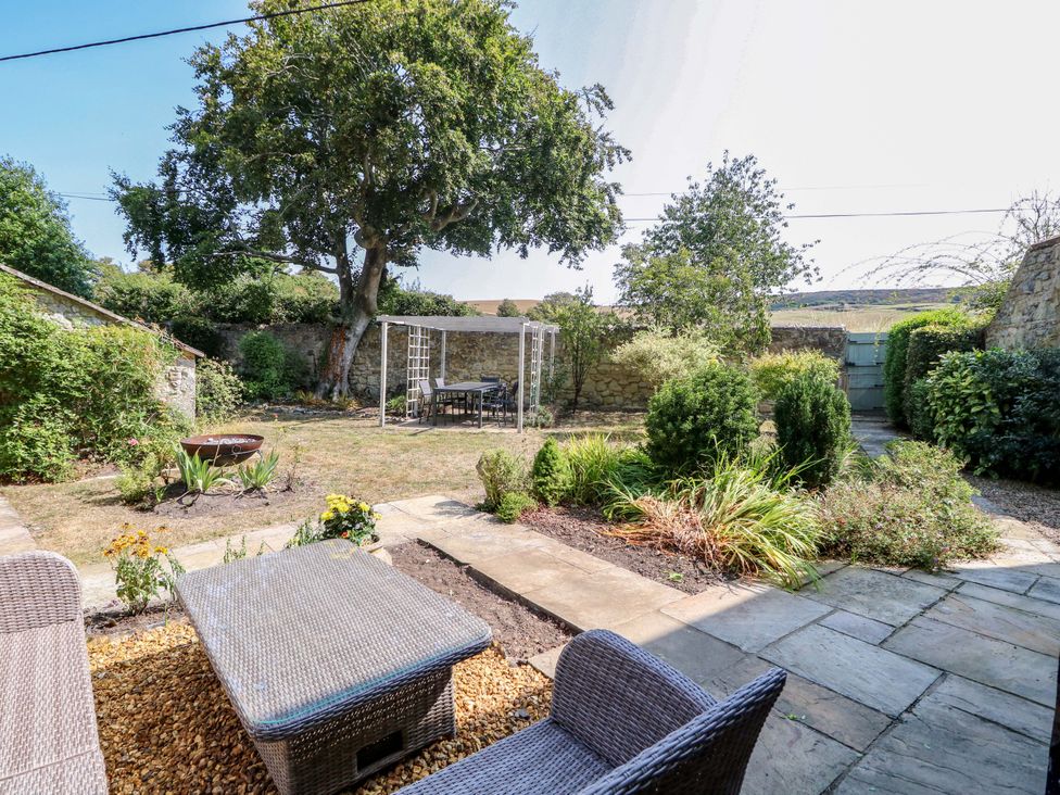 A garden with a seating area and table at Glebe Garth Chale near Niton