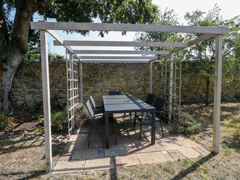 An outdoor seating area with a table and chairs at Glebe Garth in Chale near Niton