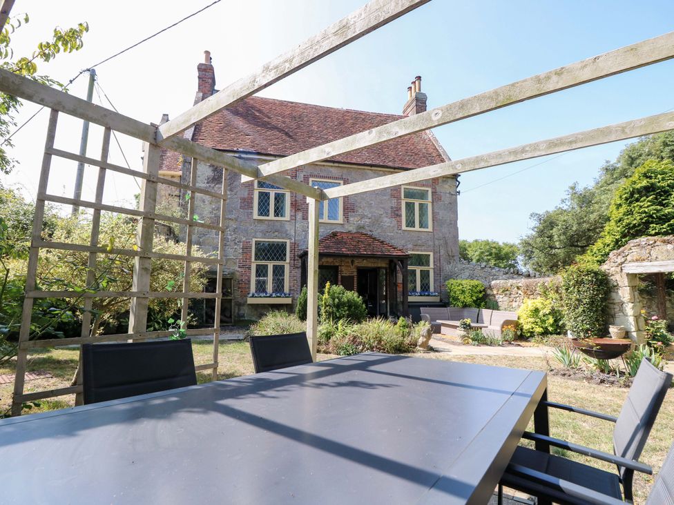 A garden with a table and chairs at Glebe Garth in Chale near Niton
