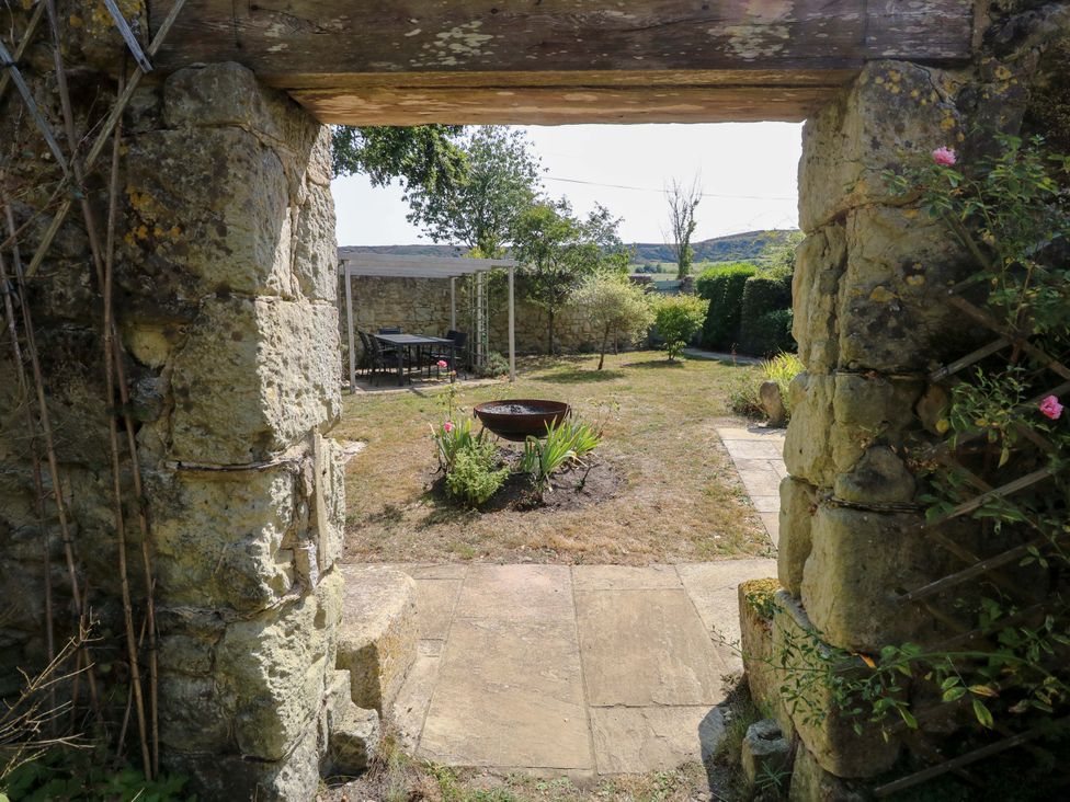 A garden view through a stone archway at Glebe Garth in Chale near Niton