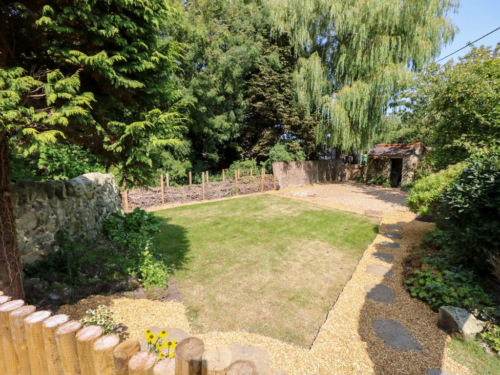 A garden with grass and trees at Glebe Garth Chale near Niton
