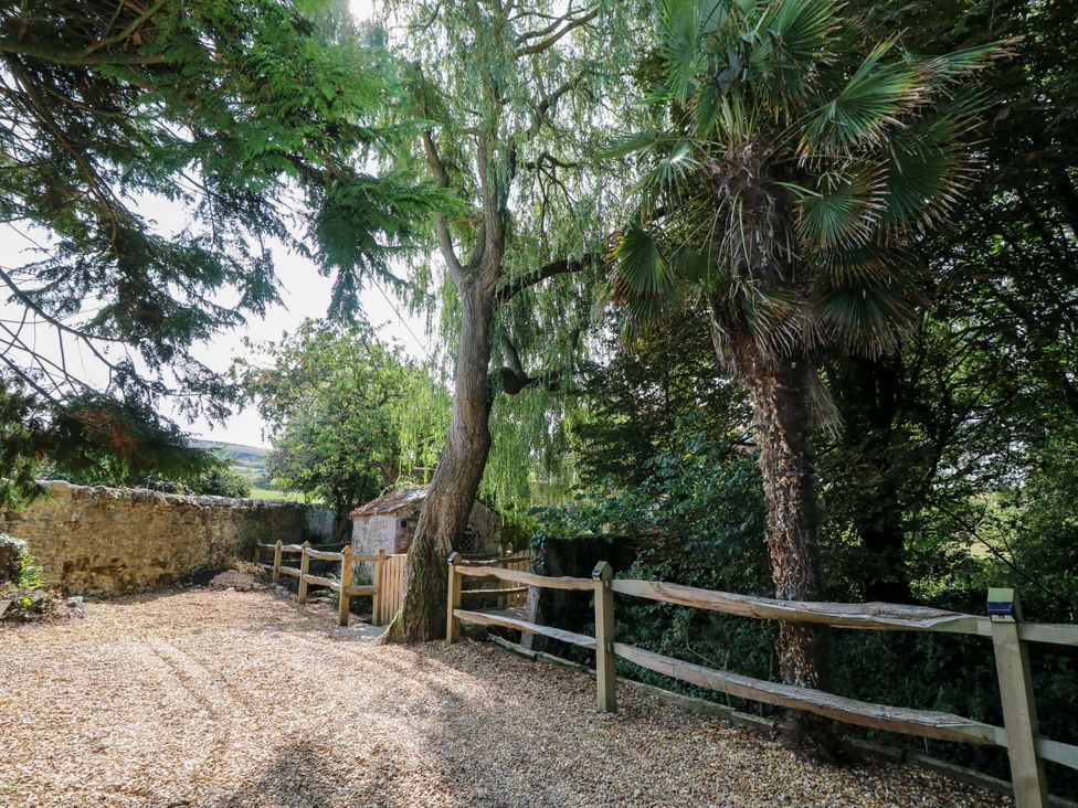 A garden with trees and a fence at Glebe Garth in Chale near Niton
