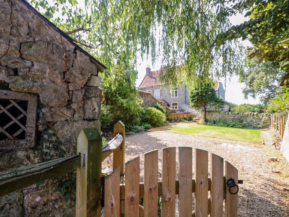 An outdoor area with a wooden gate and stone walls at Glebe Garth in Chale near Niton