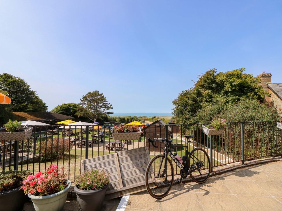An outdoor area with tables and a bicycle at Glebe Garth Chale near Niton