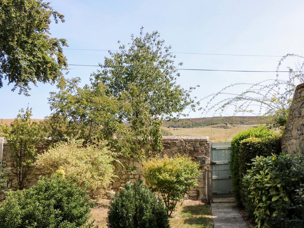 A garden with trees and a gate at Glebe Garth Chale near Niton