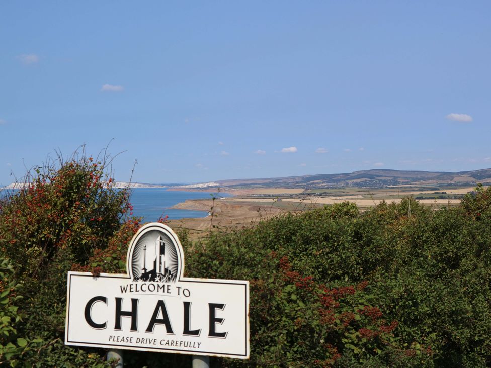 A landscape view with a sign welcome to Chale and ocean in the background at Glebe Garth, Chale near Niton