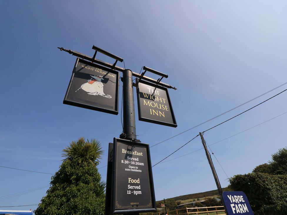 A sign for The Wight Mouse Inn indicating food and breakfast hours at Glebe Garth Chale near Niton