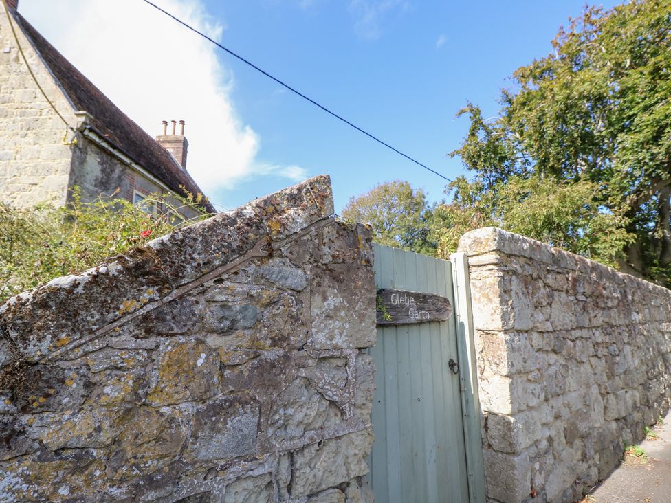 A stone wall with a wooden gate at Glebe Garth in Chale near Niton